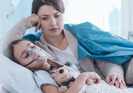 Concerned mom laying in bed with child